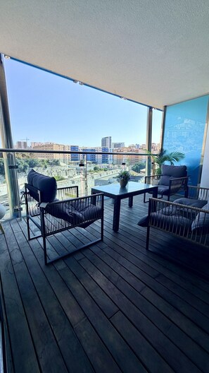 Ein Balkon mit Blick auf die Stadtlandschaft, ausgestattet mit einem Tisch und Stühlen.