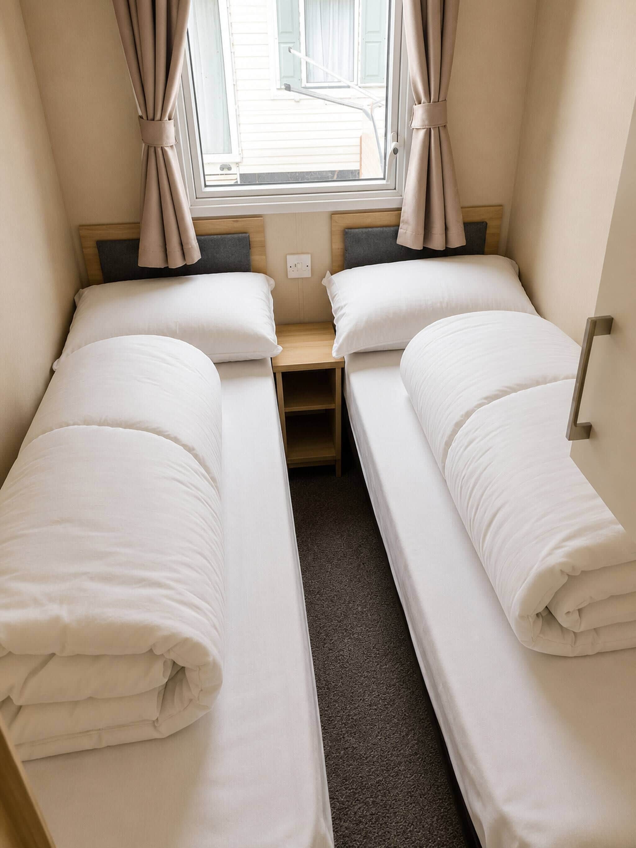 A twin room with two beds, a window, and curtains.
