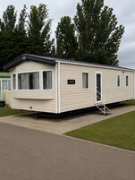 A mobile home with a number plate, windows, and a door.