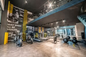 A gym with various exercise equipment, a large wall with motivational text, and a blue staircase. - Studio with King-Size Bed, Gym, Coworking Space, and Fast Check-In (Santiago)