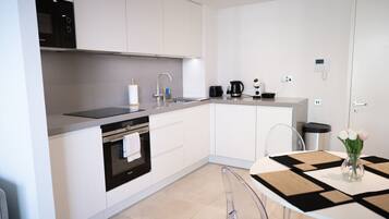 A modern kitchen with a built-in oven, a sink, and a coffee maker.