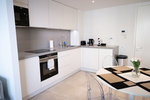 A modern kitchen with a built-in oven, a sink, and a coffee maker. - Skyline Studio EuroCity | Pool & Gym | City Centre (Gibraltar)