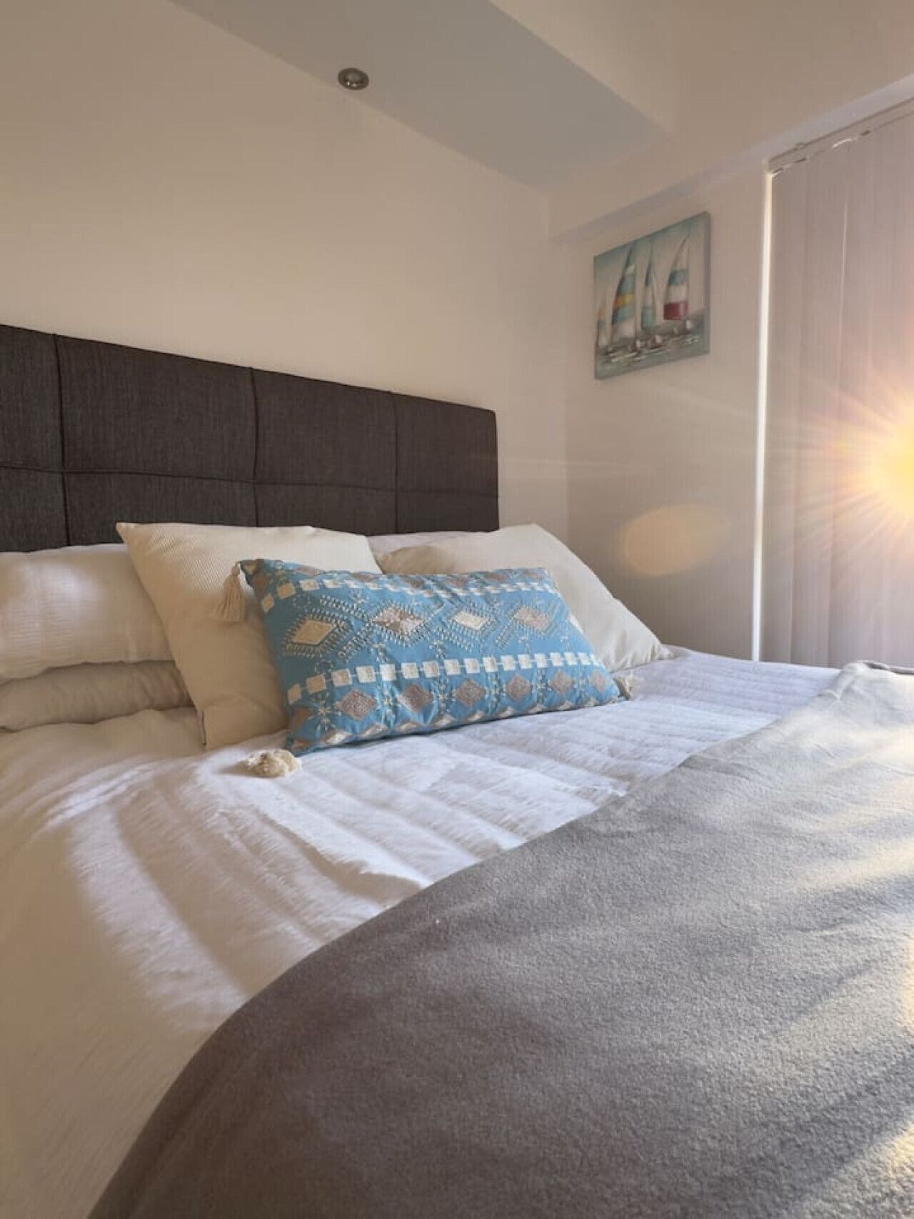 A bed with a headboard, pillows, and a blanket.