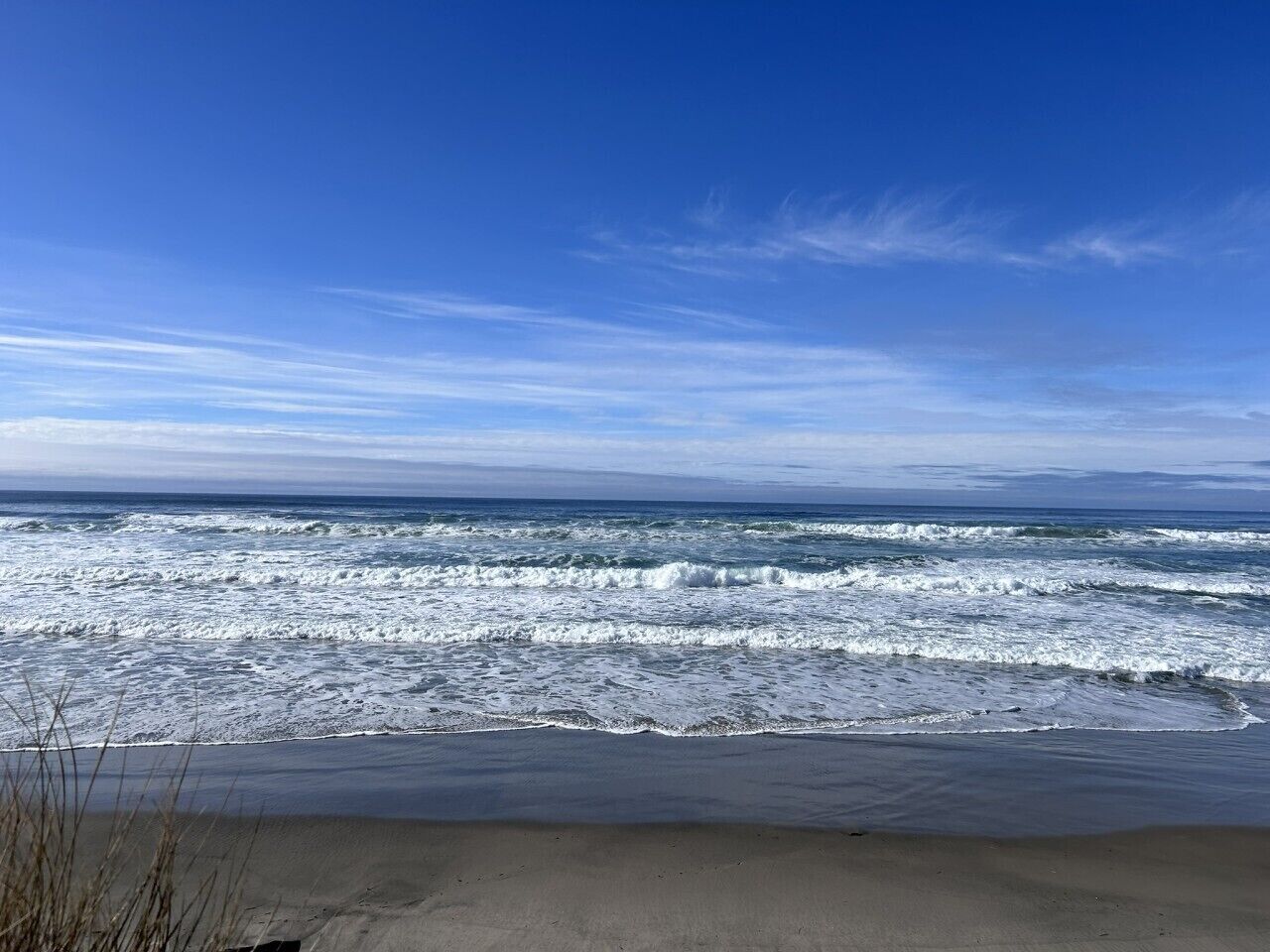 Ein Strand mit Wellen und blauem Himmel.