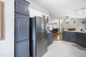 A kitchen with dark blue cabinets, a stainless steel refrigerator, and a wooden countertop. - Palisade Paradise | Quiet escape with Hot tub (Rockaway Beach)