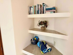 Eine Eckablage mit Büchern, einer Topfpflanze und einer Aufbewahrungsbox.