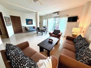 A living room with a sofa, armchairs, a coffee table, and a dining area with chairs and a table. - Rooftop Patio, Marina Views––1 Block to Beach (La Cruz de Huanacaxtle)