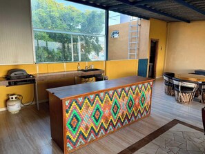 A kitchen with a wooden counter, a window, and a view of greenery outside. - Rooftop Patio, Marina Views––1 Block to Beach (La Cruz de Huanacaxtle)