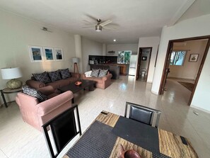 A spacious living room with a sofa set, a coffee table, and a dining area with a table and chairs. - Rooftop Patio, Marina Views––1 Block to Beach (La Cruz de Huanacaxtle)