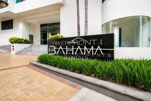 Une enseigne pour Riverfront I Bahama Rentals, avec une façade de bâtiment moderne, un escalier et un espace paysager avec de la pelouse.