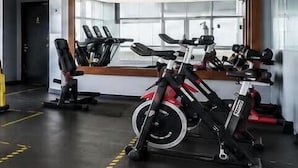 Een sportschool met trainingsapparatuur, een spiegel en een raam.