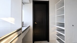 Ein modernes Interieur mit einer schwarzen Tür, weißen Regalen und einem marmorbodentile.