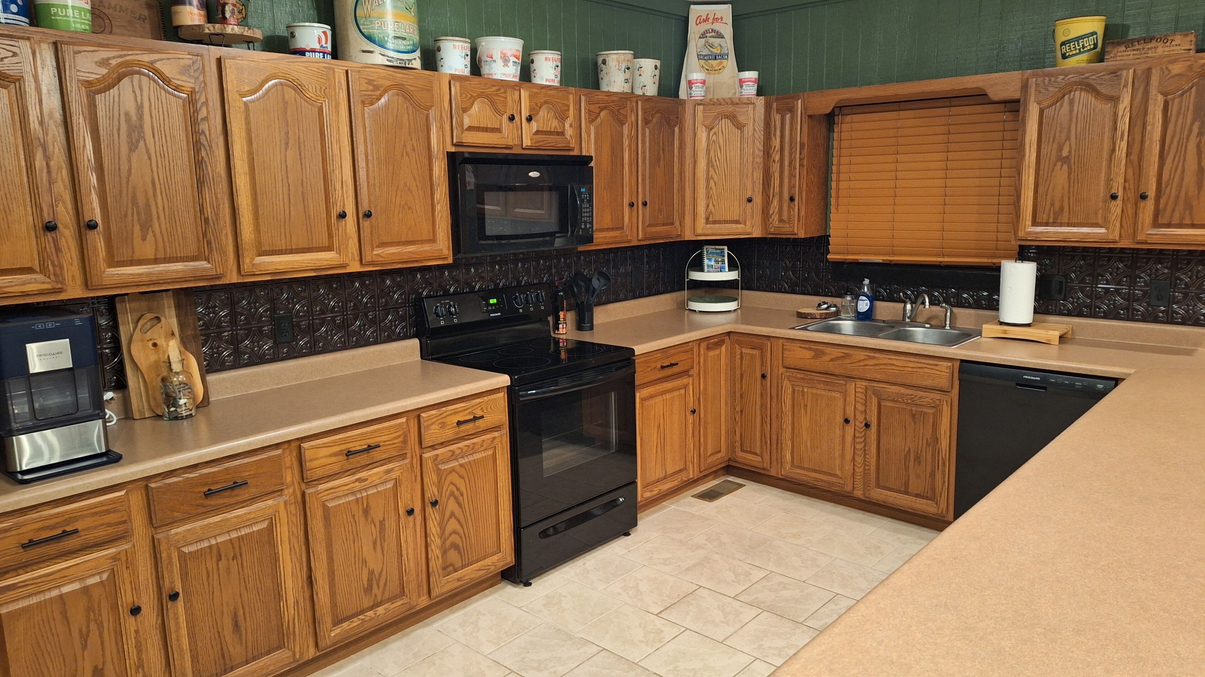 A kitchen with wooden cabinets, a black microwave, a stove, and a dishwasher.