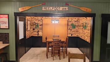 Interior de un restaurante con un diseño de pared de madera, un letrero que dice 'REELFOOT AVE.' y una mesa con sillas.