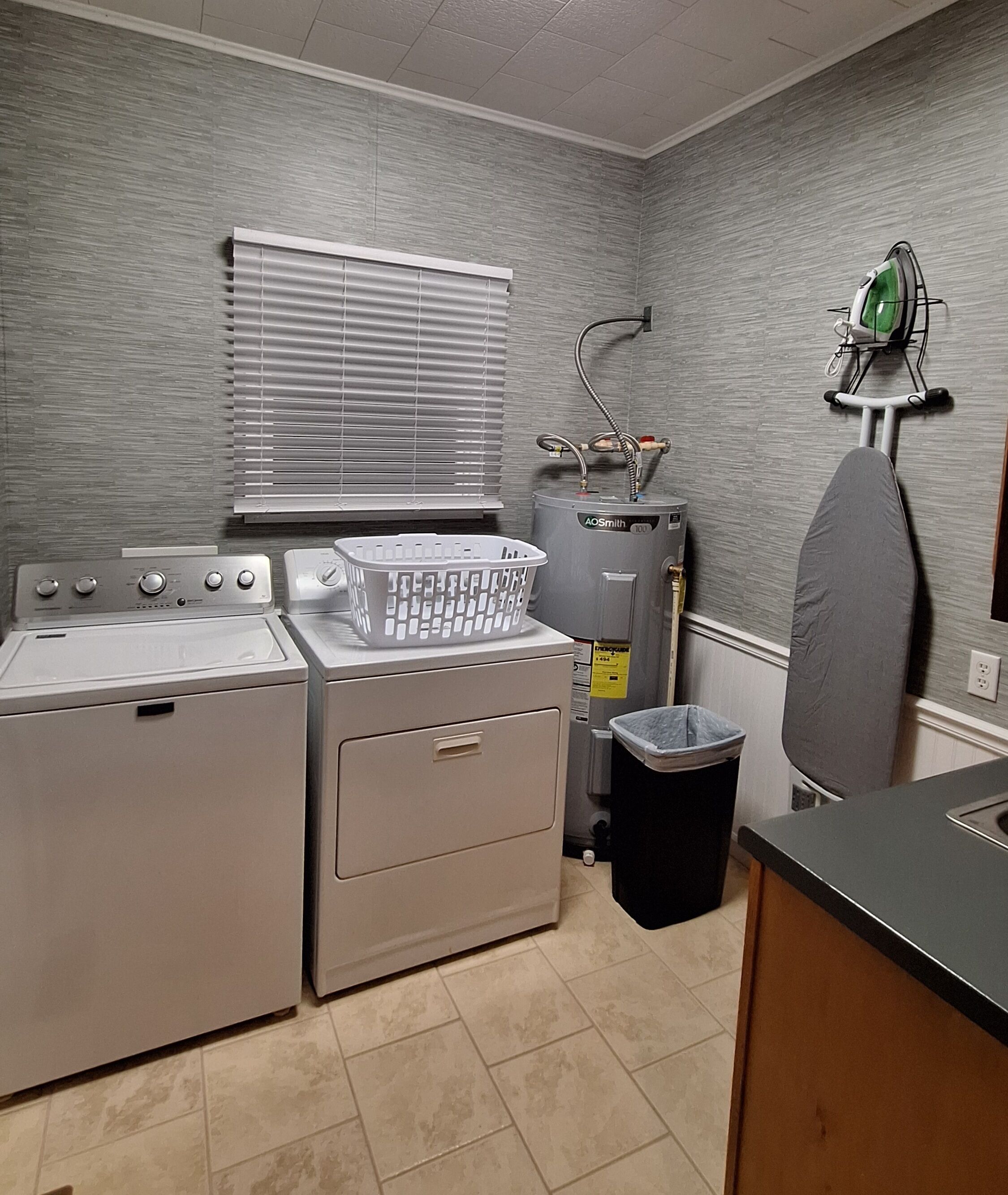 A laundry area with a washer, dryer, and a water heater.