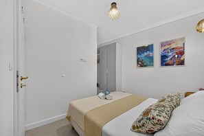 A bedroom with a bed, a bedside table, a lamp, and two paintings on the wall. - Two Bedroom Apartment with Terrace (Mlini)