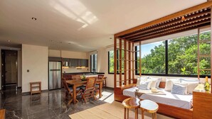 Een modern interieur met een eetgedeelte, keuken en een slaapkamer met een groot raam.