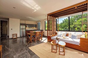 Ein modernes Interieur mit Essbereich, Küche und Schlafzimmer mit großem Fenster.