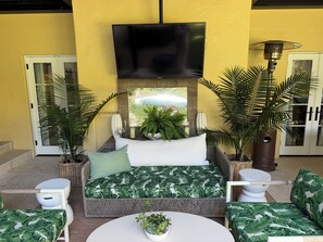 Een kamer met een bed, een televisie en een ronde tafel met een plant.