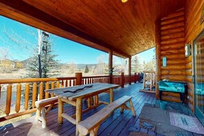 Eine Holterrasse mit Picknicktischen und Bänken, mit Blick auf eine natürliche Landschaft.