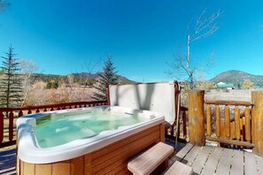 A hot tub on a wooden deck with a view of mountains. - 4BR Riverfront | Hot Tub | Fireplace (South Fork)