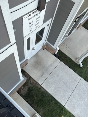A building entrance with a sign listing building numbers and a door with a handle.