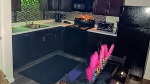 A kitchen with dark cabinets, a microwave, a stove, and a toaster.