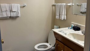Een badkamer met toilet, wastafel en twee handdoekrekken.