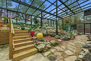 A greenhouse with wooden steps leading to a garden area with rocks and plants. - Spacious 7-bedrooms house with Pool, Close to FT Benning, Malls, Copper Creek (Columbus)