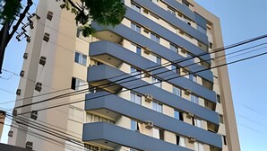 Un edificio de varios pisos con balcones, fachada plana y cielo despejado.