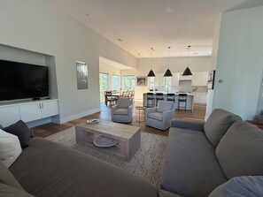 A modern living room with a flat-screen TV, a sofa, and a coffee table. - Modern Mountain Retreat in the Pines (Flagstaff)