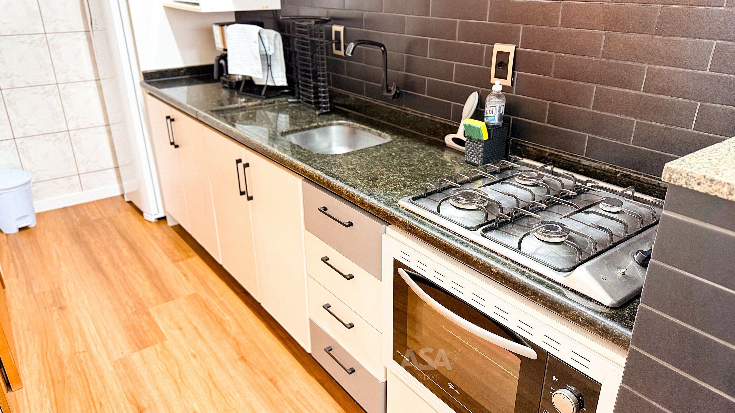 A kitchen with a gas stove, a sink, and a dishwasher.