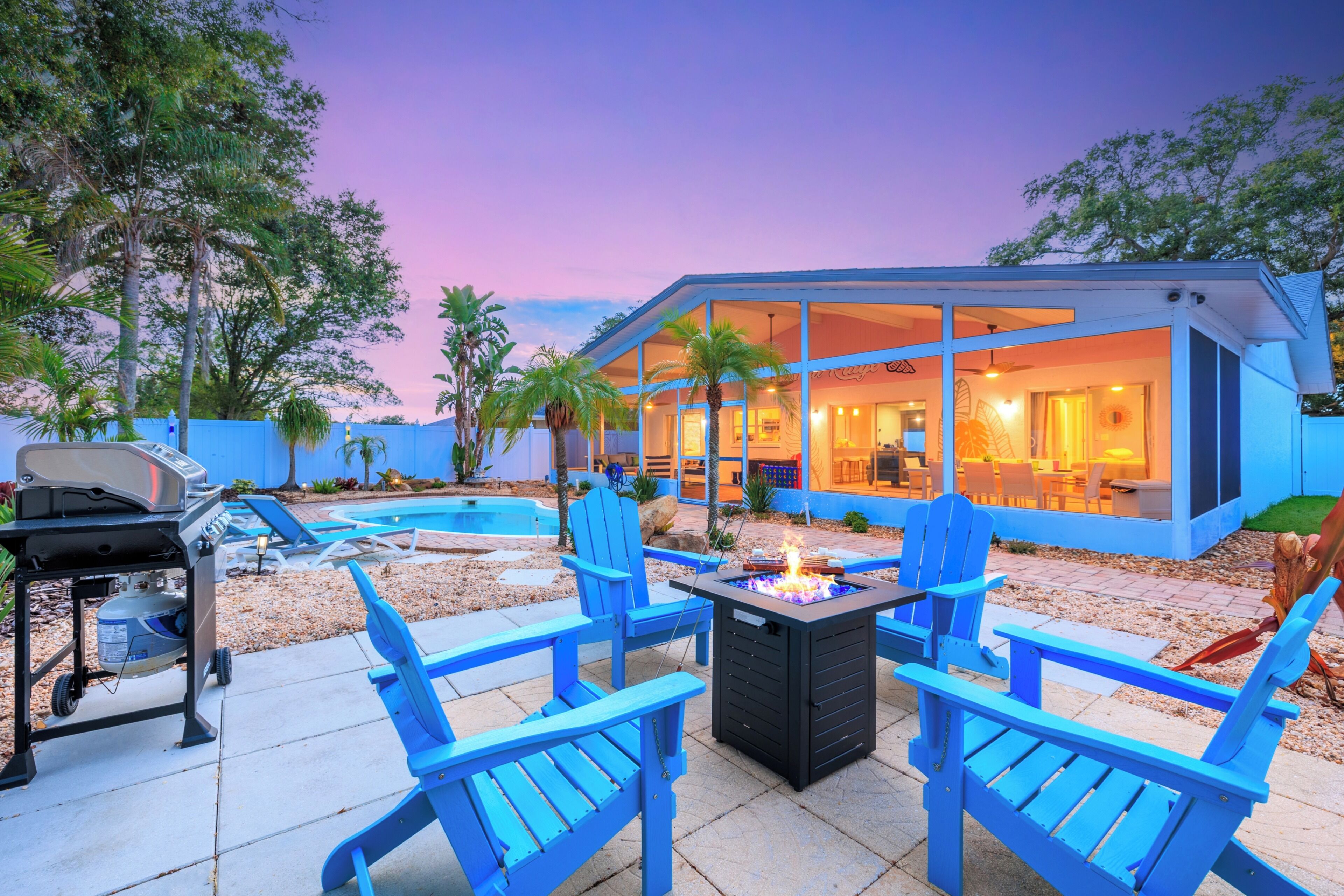 Une maison moderne dotée d’une piscine, d’un espace salon extérieur et d’un coin barbecue.