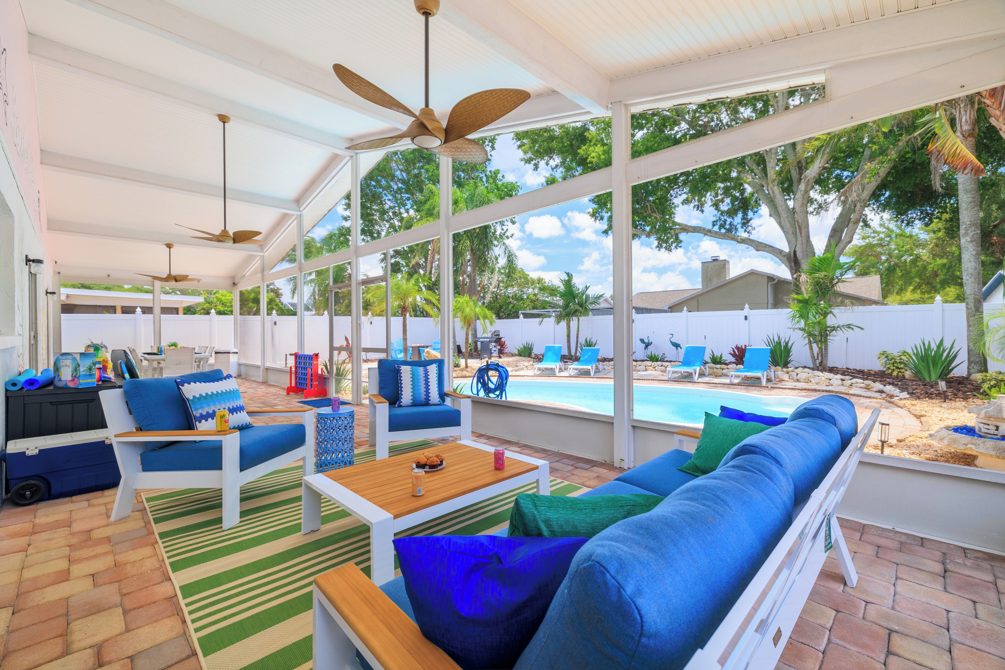 An outdoor patio with a pool, lounge chairs, and a covered seating area.