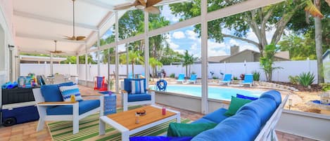 Eine Terrassenanlage im Freien mit Pool, Liegestühlen und einer überdachten Sitzgruppe.