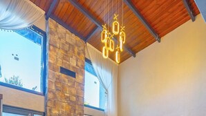 A modern living room with a stone fireplace, a green sofa, a wooden coffee table, and a ceiling light fixture. - Berra Resort (Sapanca)