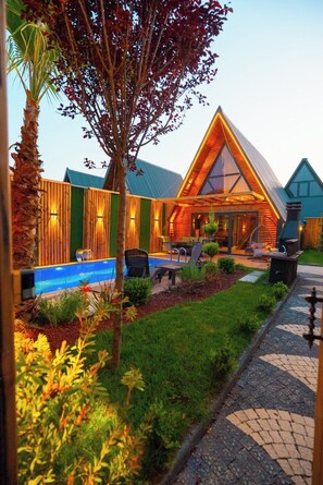 Un moderno alojamiento con piscina, mobiliario exterior y un jardín cuidado.