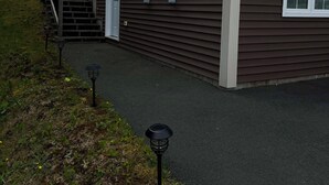 A two-story house with a dark brown exterior, a front door, and a set of stairs leading to the entrance.