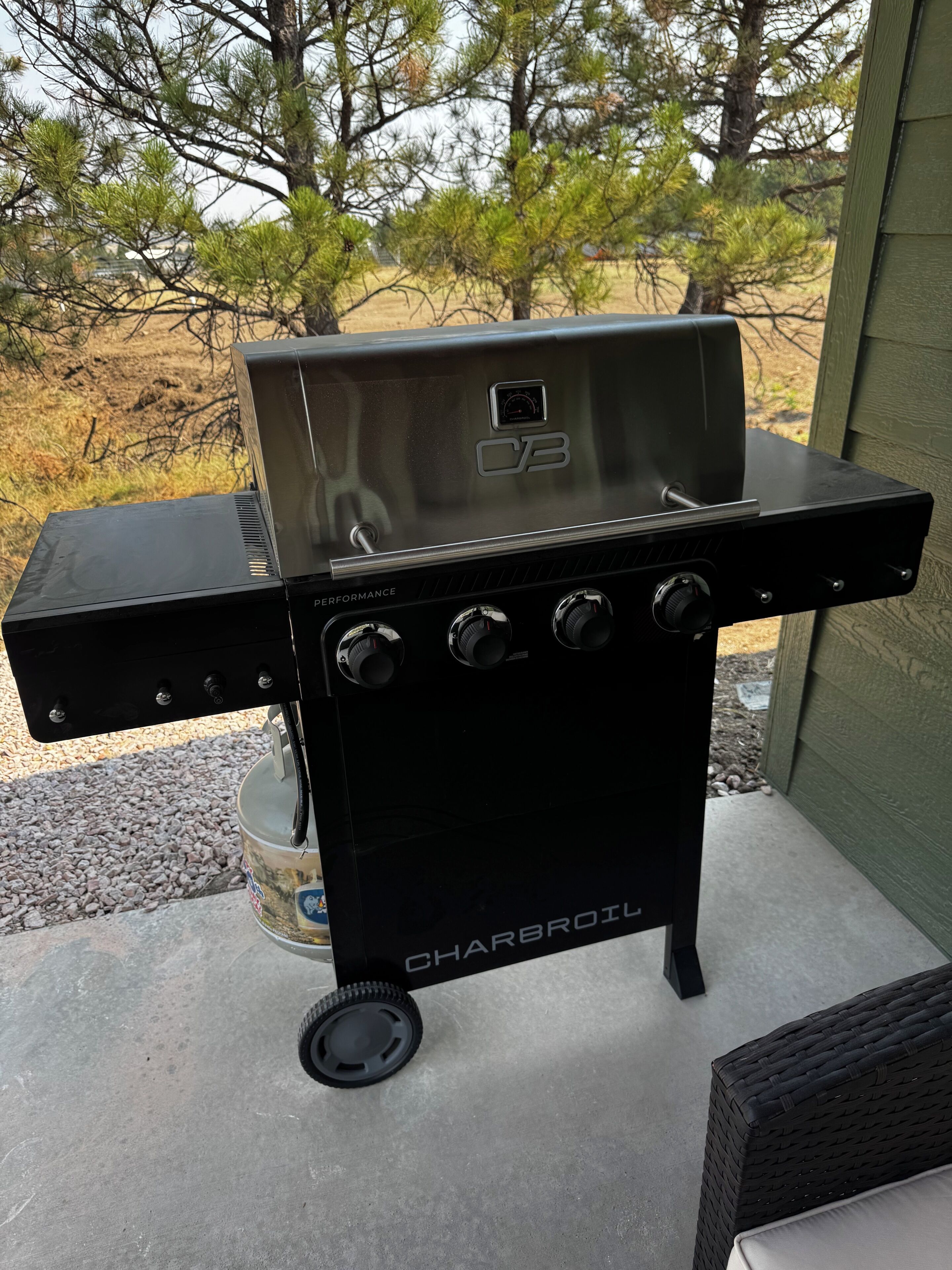 Ein tragbarer Holzkohlegrill mit digitalem Display, verstellbaren Lüftungsöffnungen und einem Brennstoffbehälter.