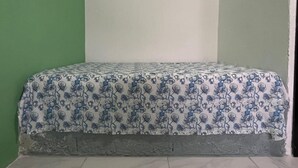 A room with a bed against a green wall and a white ceiling.