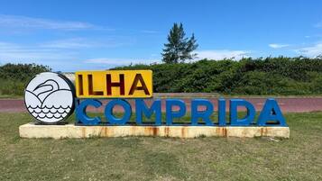 Un cartel con el texto 'ILHA COMPRIDA' y el logotipo de una ballena.