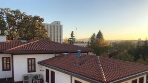 Un edificio residencial con techo de tejas, varias ventanas y una antena parabólica.