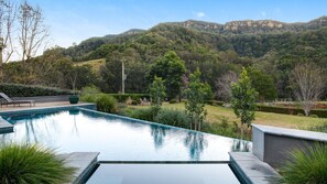 Ein Pool mit Blick auf eine hügelige Landschaft.