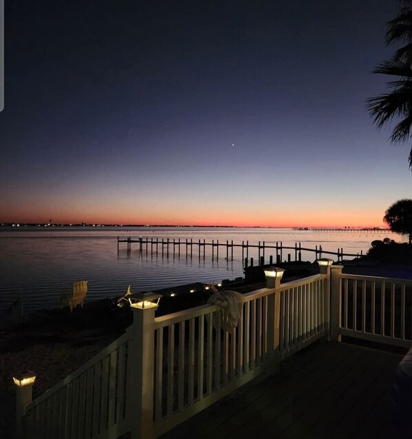 A waterfront property with a wooden deck, a railing, and a view of the water. - Waterfront Views & Beach Access - Pet Friendly! (Navarre)