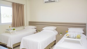 A hotel room with two beds, a window with curtains, an air conditioning unit, and a breakfast tray on the right side. - Hotel Imperador (Gurupi)