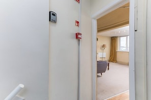 Ein Hotelzimmer mit einem Bett, einer Lampe und einem fenster mit Vorhängen.