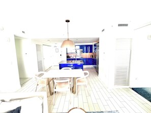 A modern kitchen with blue cabinets, a central island, and a pendant light. - Cozy 2-bedroom Condo At W Residences Fort Lauderdale With Pool & Beach Service (Fort Lauderdale)