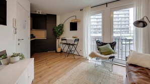 Un appartamento moderno con cucina, zona pranzo e un balcone con vista sulla città.