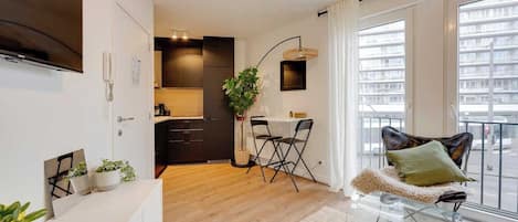 En moderne lejlighed med et køkken, spiseområde og en balkon med udsigt.