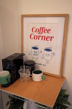 A framed sign with cartoon characters and the text 'Coffee Corner' on a wooden table. - Stylish City Apartment with Lift in Antwerp Zuid (Antwerp)